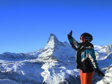 Student posing in ski gear on a mountain top