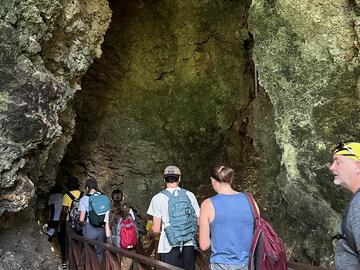 Group crossing bridge into cave
