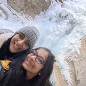 Selfie of two students in front of a frozen waterfall