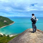 Selfie of student standing on hill overlooking beach blue water