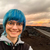 Selfie of a student on a volcano peak at sunset