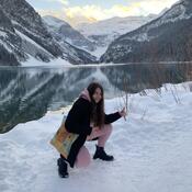 Student posing in front of Lake Lousie and mountains in the snow