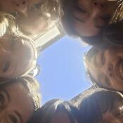 Students crammed into the frame looking down at the camera
