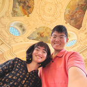 Students looking down at the camera with a ceiling mural 