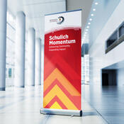 A pull-up banner in a long bright hall