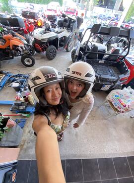 Selfie of two students wearing racing helmets