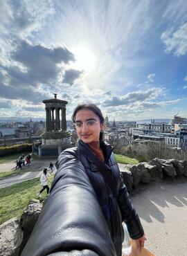 Student taking a selfie with a city and garden view of the city