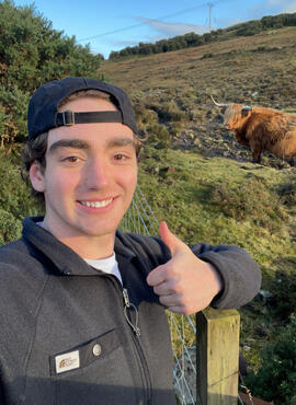 Student posing with a cow
