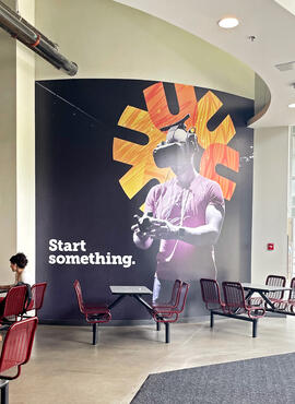 Mural of a person wearing virtual reality goggles with Start something graphics