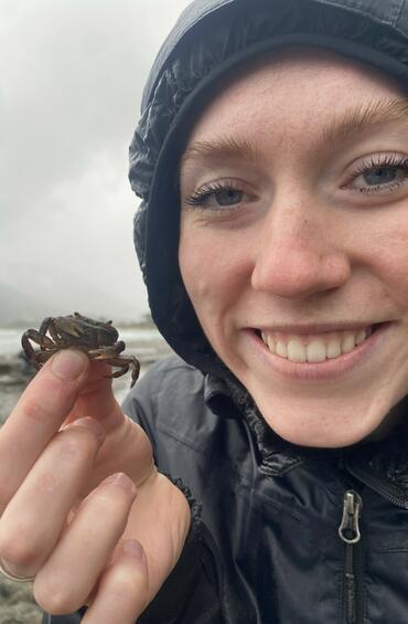 Selfie of a student holding a tiny crab