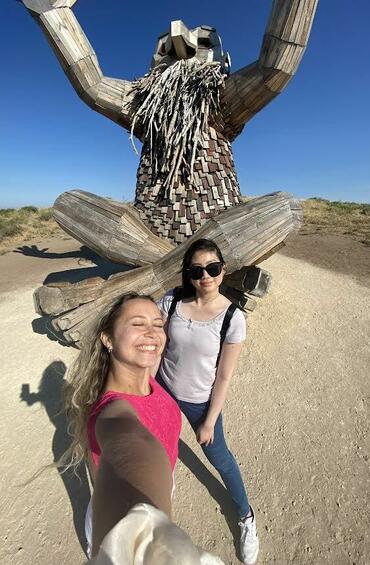 Selfie of two students in front of a statue
