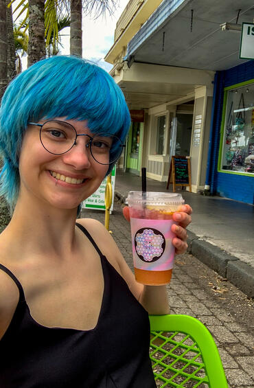 Selfie of a blue haired student holding lemonade cup with a straw