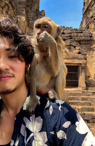 Selfie of a student with a small monkey on their back