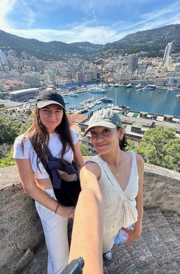 Two students posing at a view point of Monte Carlo city - buildings, ocean and boats
