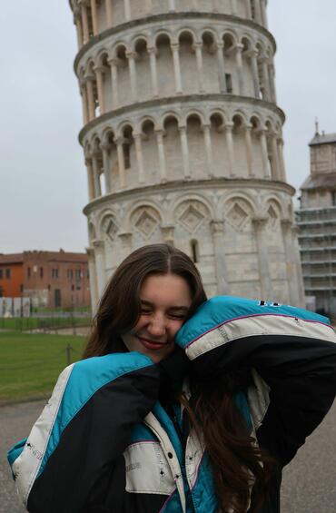 Student smiling in front of the Leaning Tower of Pisa