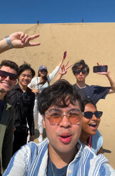 Students posing together in the sandy desert