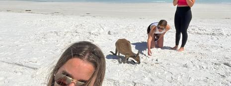 Selfie of students on beach with kangaroo