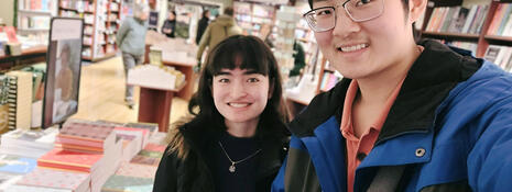 Two students posing in a book store