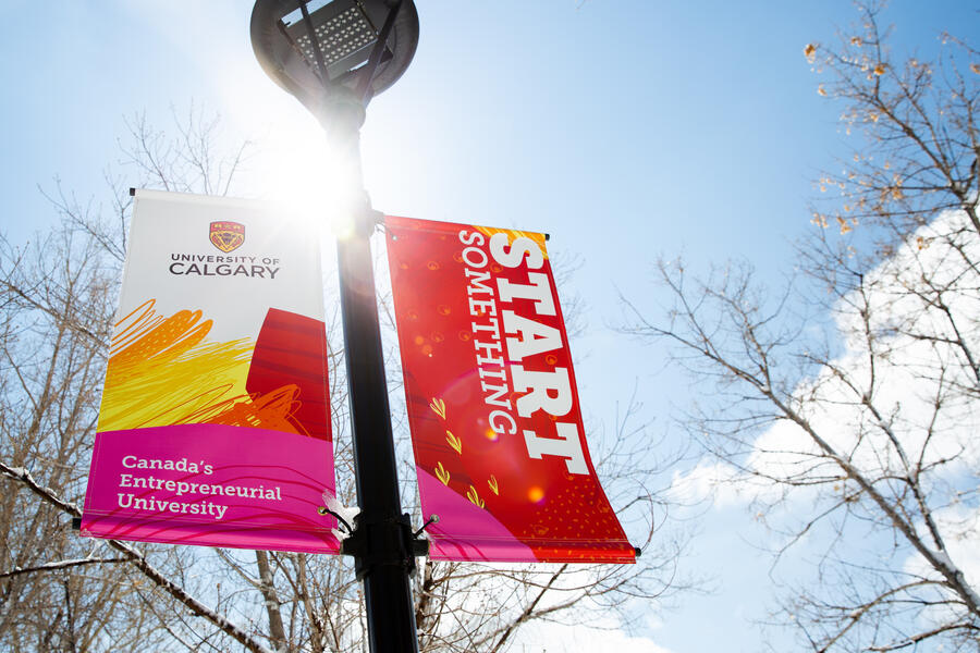 A lamp post with colourful UCalgary pageantry hanging from it