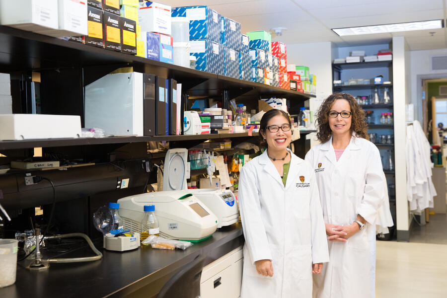 two women in lab coats, in a research lab