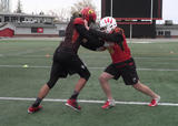 Football athletes performing standing partner wrestling