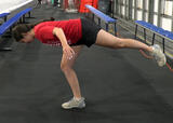 Athlete performing airplane balance exercise in an ice hockey arena