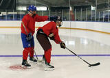 Hockey players performing partner bobbleheads with stick handling exercise on a hockey rink