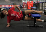Athlete performing knee-supported copenhagen adductor exercise in an ice hockey arena