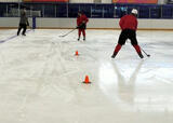 Hockey players performing a figure 8 passing with shoulder checks drill on a hockey rink