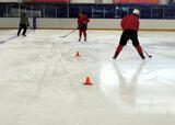 Hockey players performing a figure 8 passing with shoulder checks drill on a hockey rink