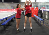 Athletes performing a jump with partner push exercise in an ice hockey arena