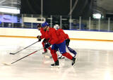 Hockey players performing single-leg glides across a hockey rink