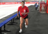 Athlete performing skate jumps exercise near a hockey rink