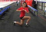 Athlete performing walking lunges with rotations exercise near a hockey rink