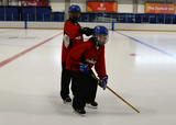 Ringette players performing partner bobbleheads in a ringette stance without a ring