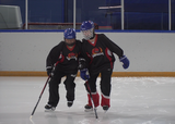 Ringette players performing partner shoulder skate exercise