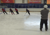 Ringette players performing a reaction change of direction exercise, cutting into the same direction that the coach points to