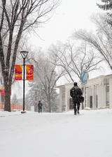 people walking on snowy pathways on main campus