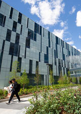 Two students walk between the Taylor Family Digital Library and MacKimmie Tower