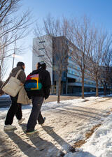 Students walking past a residence building on main campus