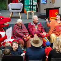 Community event. Rex dino mascot costume on left
