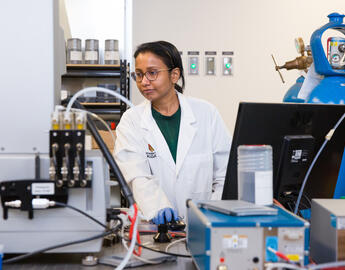 Woman working in lab coat working on a computer