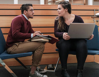 Two students study on a laptop