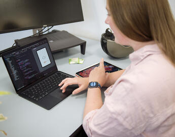 A student looks at a computer with code on it.