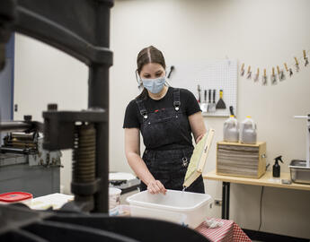 A student making paper in a lab.