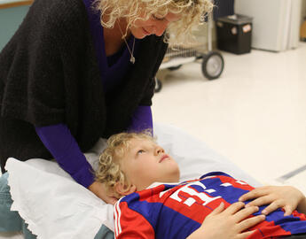 Dr. Kathryn Schneider performing neck exam