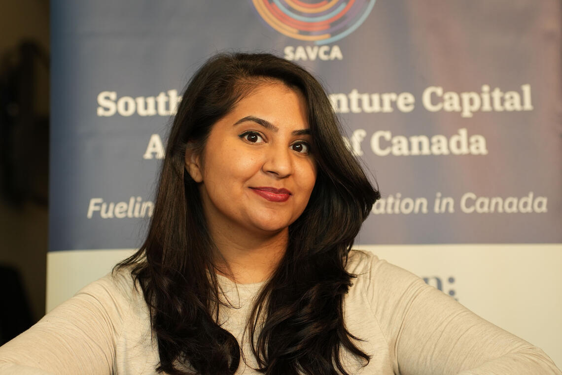 A woman with long dark hair smiles at the camera
