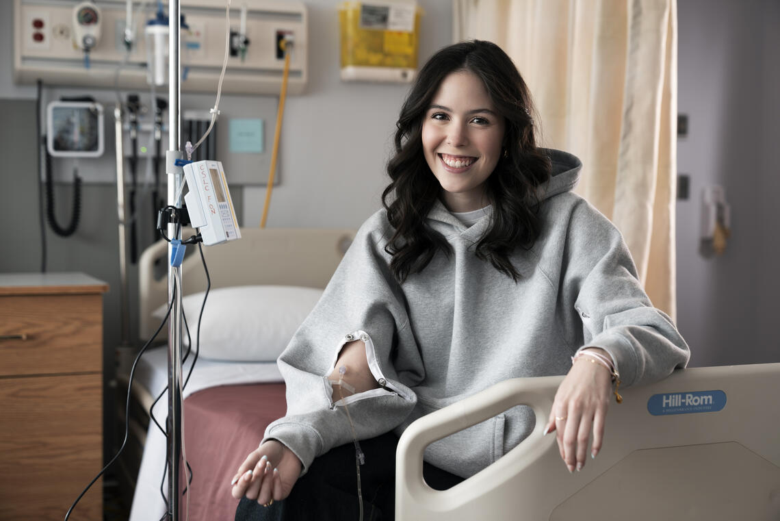 A woman wears a hoodie while receiving an IV treatment