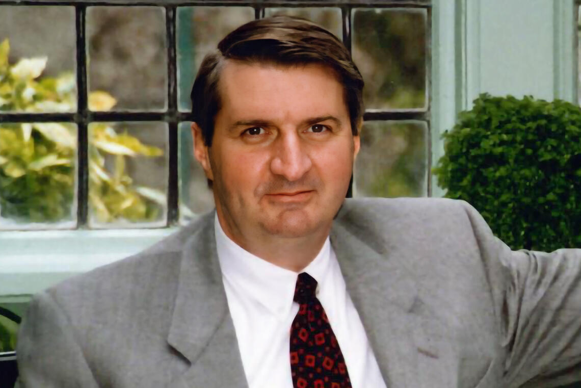 A man with short dark hair wearing a suit