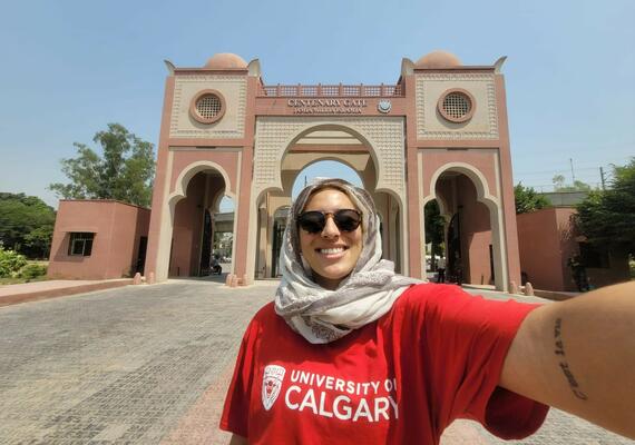 A woman wearing a hijab takes a selfie in front of a building